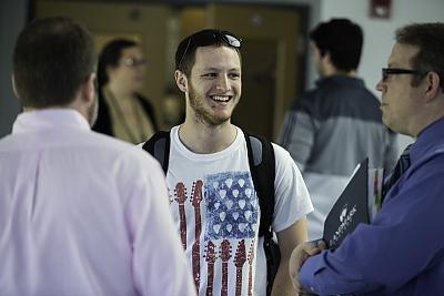 Student wearing American flag t-shirt talks to Landmark College staff member