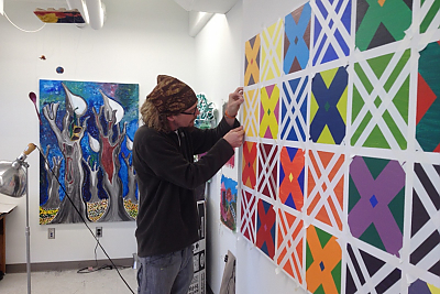 Art student works on geometric mural