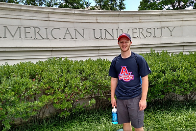 Everett Law standing in front of American University sign